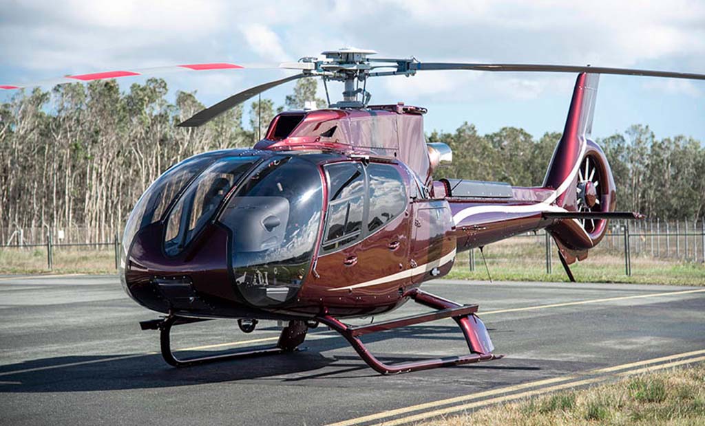 H130 Completion Maroon Gold Airbus EC130 T2 on airstrip