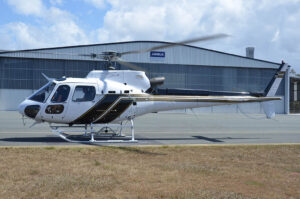 Airbus AS350 B3 in front of Pacific Crown Helicopters hangar