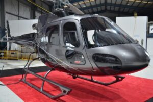 Airbus AS350 helicopter in a hangar on red carpet
